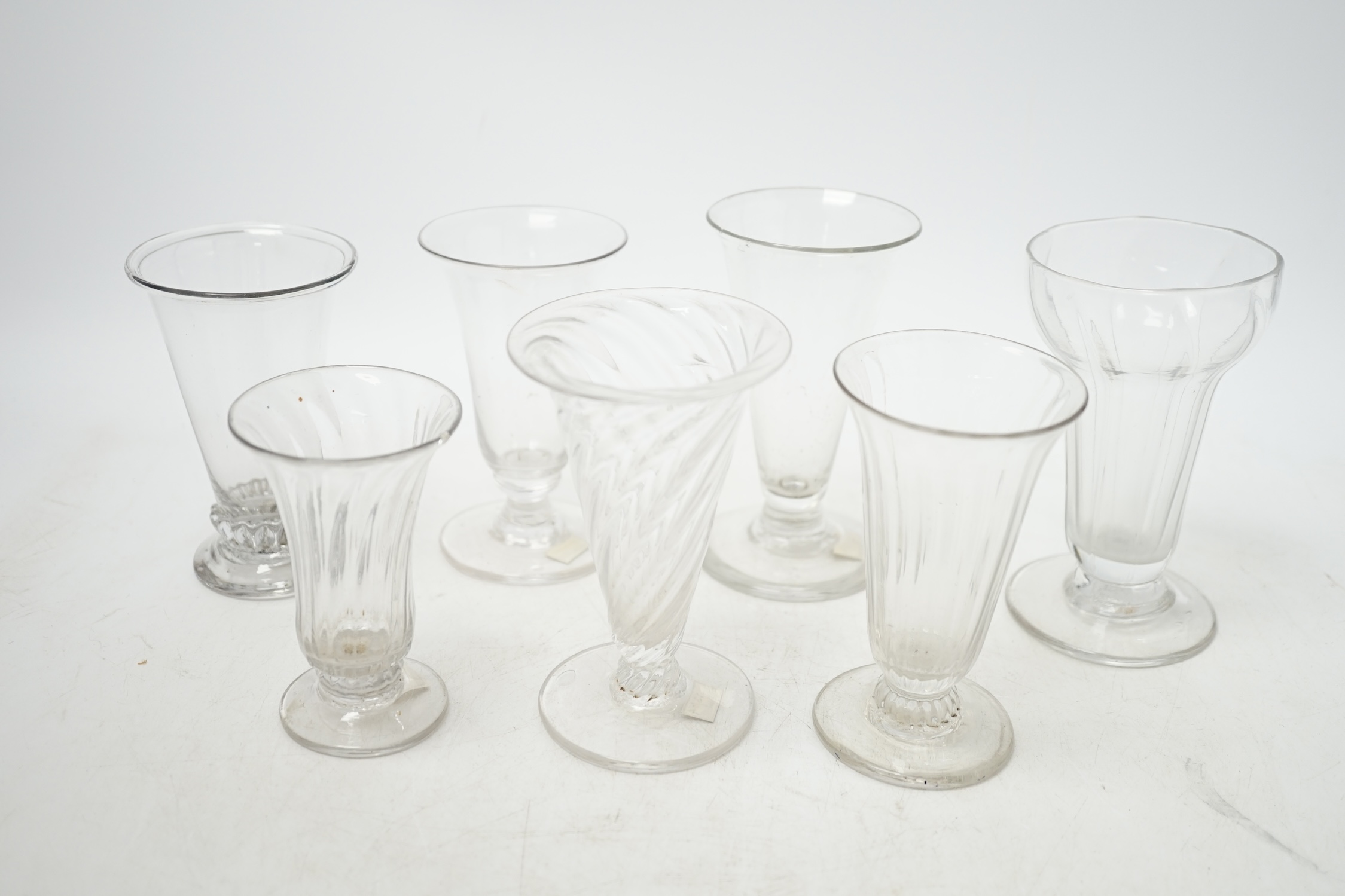 Seven 18th century jelly glasses, four with ribbed bowls, tallest 11.5cm. Condition - fair to good, chip to the rim of one and faults in the blowing.